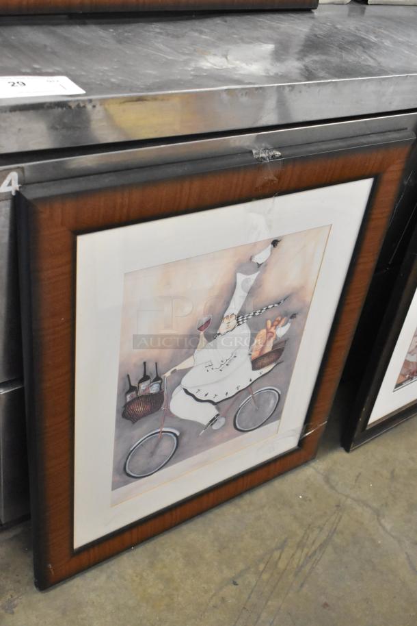 Framed picture of a chef on a bicycle with wine and bread. Dark wood frame, part of a 7-item lot including a clock.