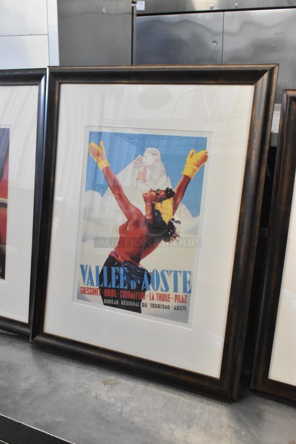 Five framed pictures, featuring vibrant vintage-style art, in dark wood frames. Highlight: "Valle d'Aoste" tourism poster.