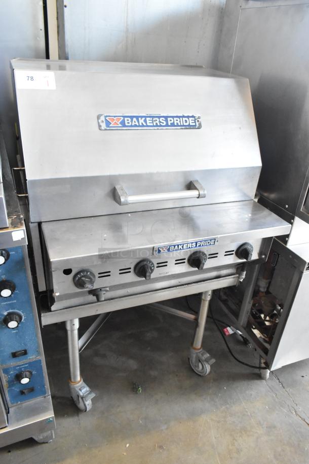 Bakers Pride CBBQ30S stainless steel propane charbroiler grill on commercial casters, featuring multiple controls and branded cover.