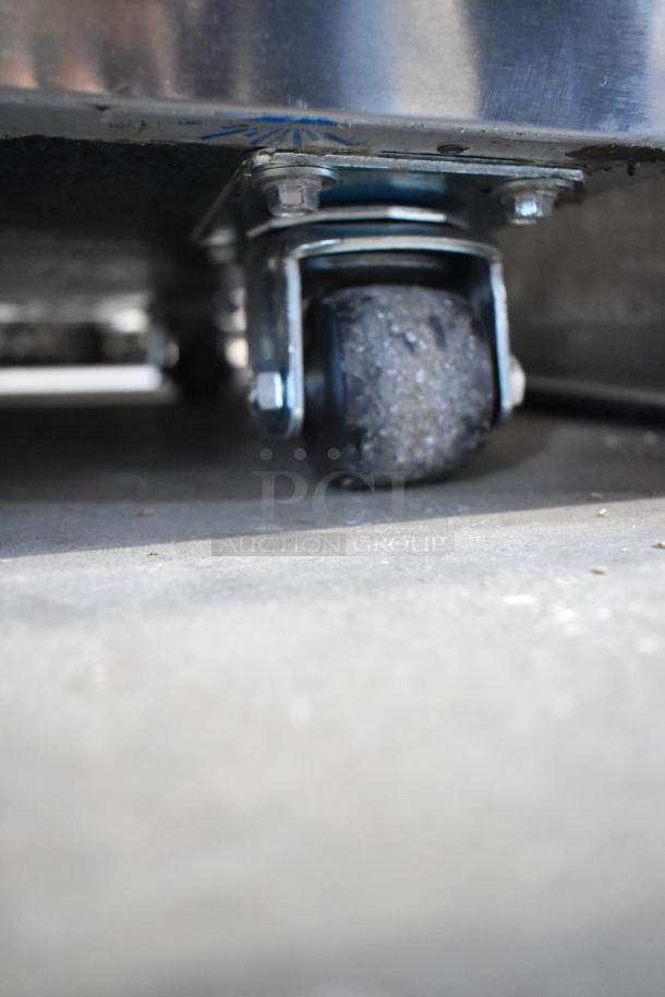 Close-up of a caster wheel of a Perlick DDS36 36" stainless steel beer dispenser with visible scratches.