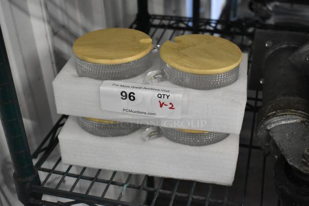 Lot of 4 brand new glass mugs with wooden lids. Textured glass design. Auction label reads: "96, QTY V-2."