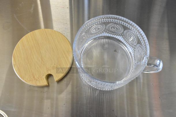 Brand new glass mug with intricate patterns, clear design, detachable wooden lid, excellent condition.