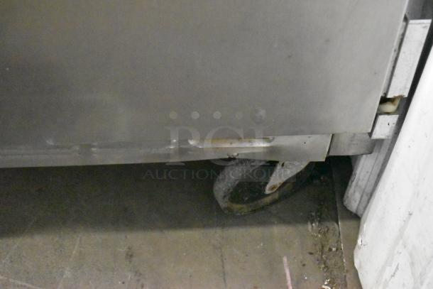 Beverage Air SP48-08 stainless steel prep table, visible commercial caster, shown in used condition with surface wear.