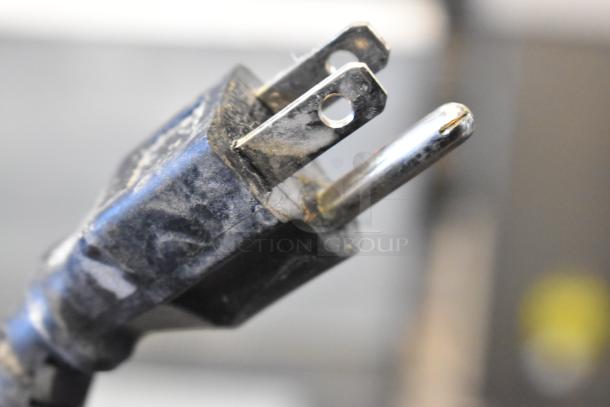 Close-up of a three-pronged electrical plug for the 2023 Sir Lawrence SLMPREP-2DW prep table.