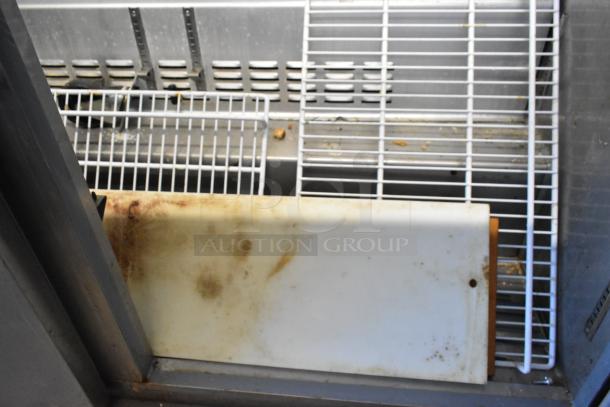 2023 Sir Lawrence SLMPREP-2DW Stainless Steel Prep Table, visible cutting board and wire racks, some wear visible.