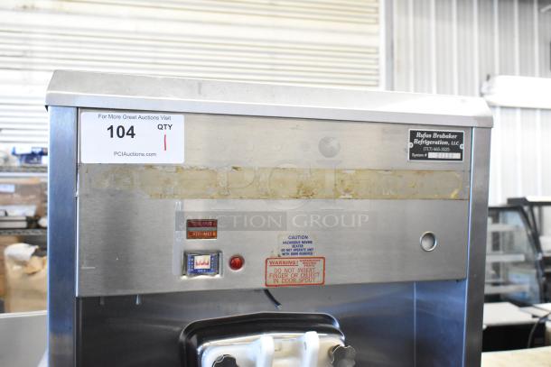 Taylor 8752-27 stainless steel soft serve ice cream machine on commercial casters. Visible usage marks, labels with operational cautions.