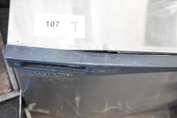 Scotsman C1030MA-32B Prodigy Plus ice machine, stainless steel, 1077 lb capacity. Visible wear on stainless exterior. Auction tag reads "107."