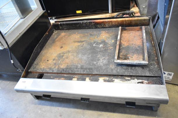 Radiance stainless steel commercial flat top griddle, natural gas powered, visible rust and wear on cooking surface.