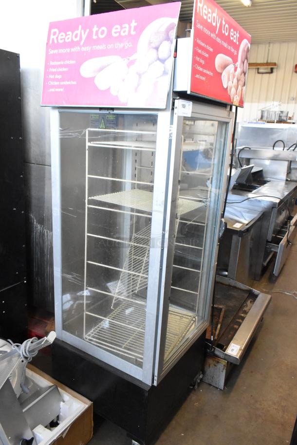 Metal commercial heated holding cabinet with racks, damaged door handle, pink "Ready to Eat" sign atop.