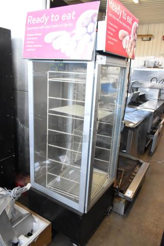 Metal commercial heated holding cabinet with racks, damaged door handle, pink "Ready to Eat" sign atop.