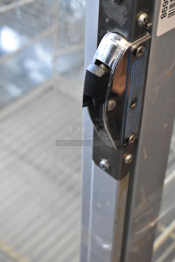 Commercial heated holding cabinet with racks, metal construction. Door handle broken; cannot open. Needs handle replacement.