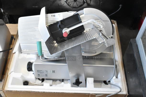 2018 Bizerba GSP H metal countertop meat slicer, 120V, 1 phase, in good condition, silver with green handle, includes protective packaging.