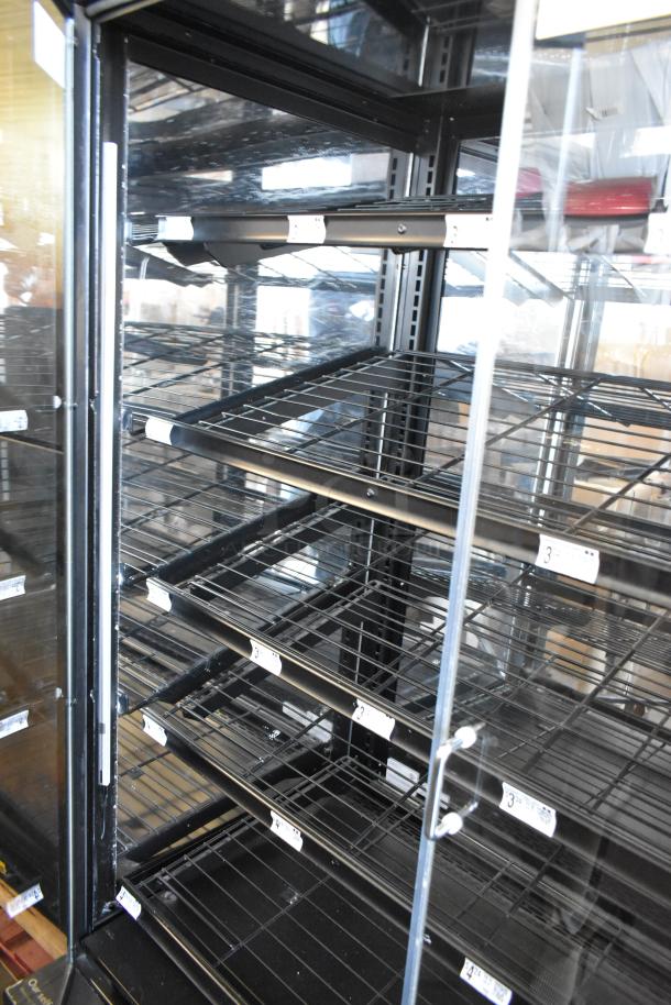 Dry floor style bakery bagel donut merchandiser with multiple wire shelves and clear glass door. Used condition, some price labels visible.