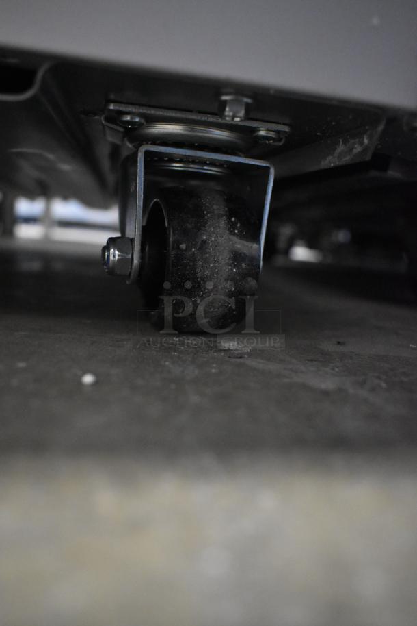 Brand new KoolMore KM-ICD-49SD ice cream cabinet wheel detail. Metal, 8 tub capacity, sliding glass door, 115V.