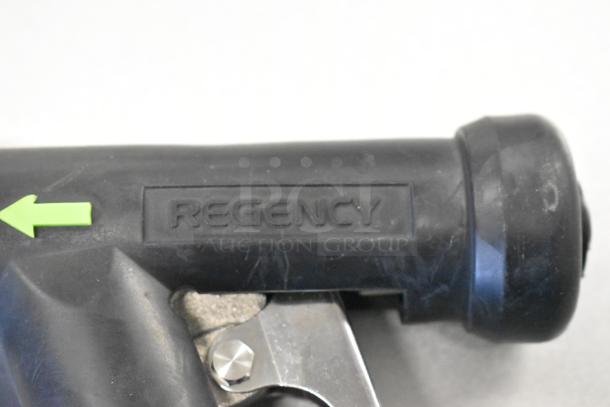 Close-up image of Regency-branded black swivel caster part. Visible scratch marks. Green directional arrow sticker.