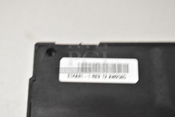 Image of a black component with a white label showing a barcode and text. Part of an auction set including Garland oven parts and Southbend spring.
