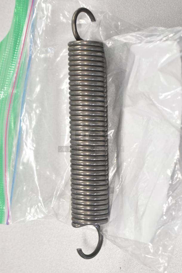 Brand new Garland oven door spring 4512585 in a clear plastic bag, showing metal coils and hooks.