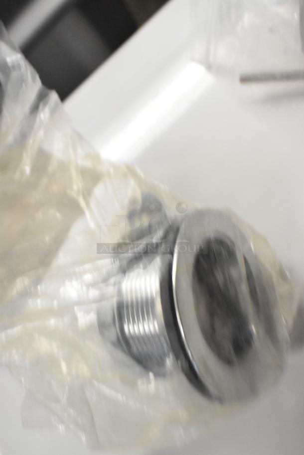 Bag containing new metallic fitting, partially visible. Item: Cleveland 06230 Fitting Compartment Drain HP06230.