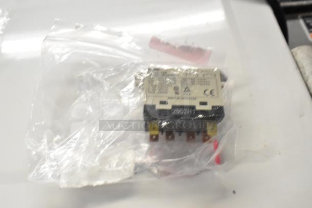 Packaged relay in clear plastic, labeled with electrical specs and CE marking. New condition, part of mixed auction lot.