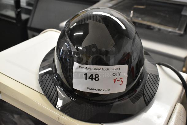 Carbon fiber helmet with a visible sticker indicating auction lot number 148, showing minor scratch and dent marks.