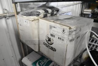 5 brand new items including a 7.5' black and white stripe umbrella canopy and Oxford super blend navy napkins. Boxes show light wear.