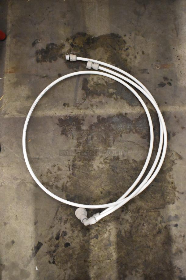 White poly scooper hose with attached fittings on a concrete floor, part of a 7-item scratch and dent auction lot.