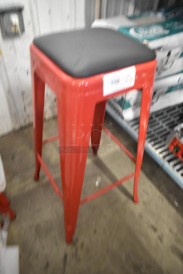Red metal bar stool with black cushioned seat; new, scratch and dent condition. Includes 15 items per bid.