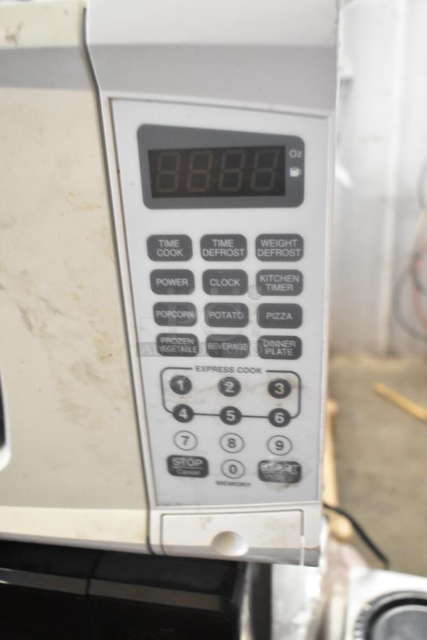 Two countertop microwave ovens. Models: RGTM701, MS8436127995-01. Features keypad controls. 120V, 1 phase. Includes plate.