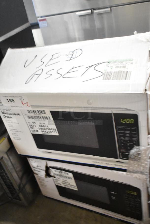 Two used 2025 MS8436127995-03 countertop microwave ovens with plates, 120 volts, 1 phase. Packaging marked "Used Assets."