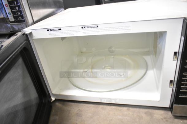 2023 Panasonic NN-SN975S stainless steel countertop microwave oven, open door view, glass turntable, used condition.