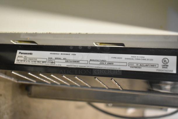 2023 Panasonic NN-SN975S Microwave Oven label showing model, serial number, and manufacture date. Stainless steel finish.
