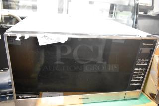Panasonic stainless steel countertop microwave oven, featuring digital controls and 1250W inverter technology. Slight wear visible.