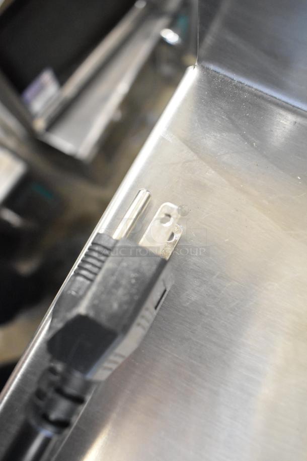 Power plug of 2024 Sharp R-21LVF stainless steel commercial countertop microwave, 120 volts, on stainless surface.