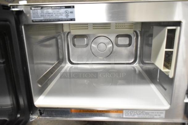 2024 Sharp R-21LVF stainless steel commercial microwave, 120 volts, pristine interior, label detailing specifications visible.