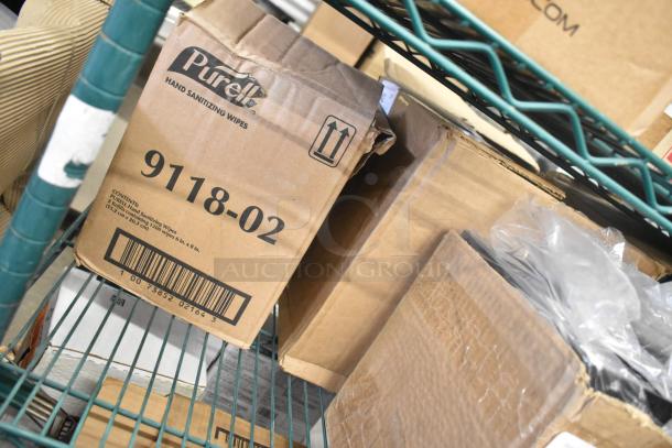Cardboard boxes of new items including 9118-02 Purell Hand Sanitizing Wipes visible on a shelf. Scratched and dented.