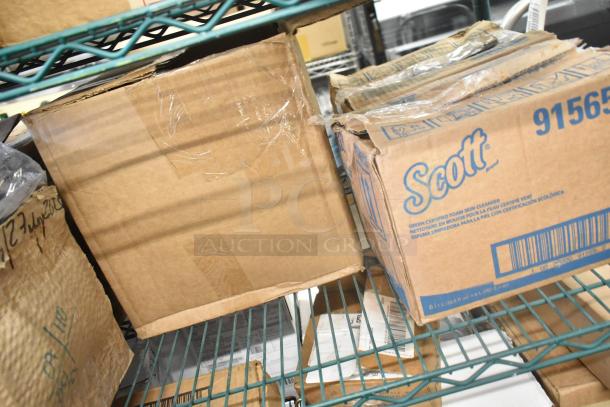 Boxes on a shelf, including a marked Scott 91565 Foam Skin Cleanser box. Some boxes show slight wear.