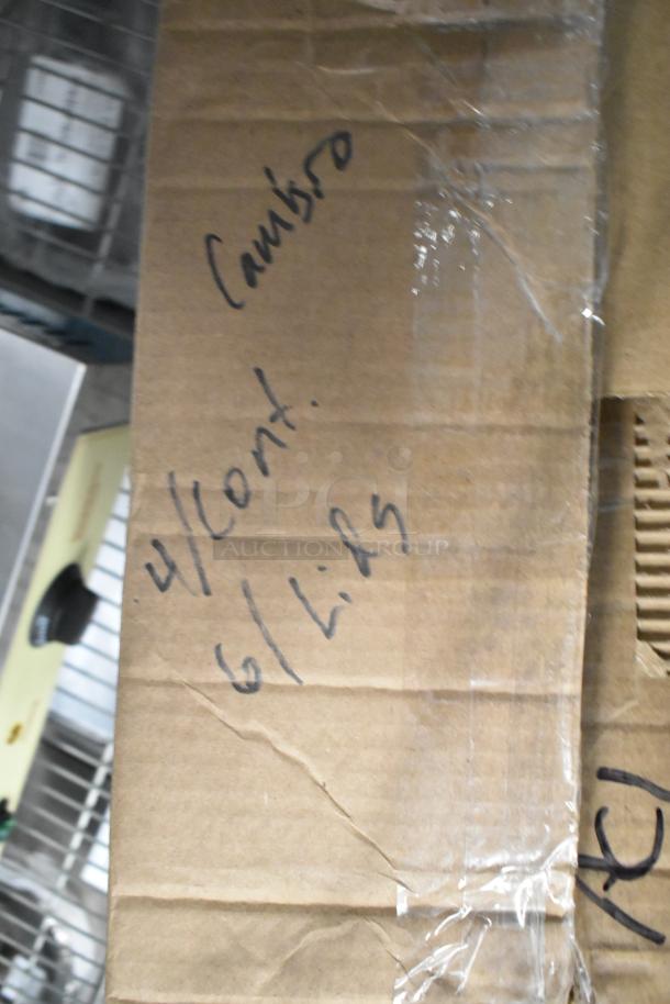 Cardboard box with handwritten text "Cambro, 4/Cont., 6 Lids." Contains scratch and dent hotel pans and bins.
