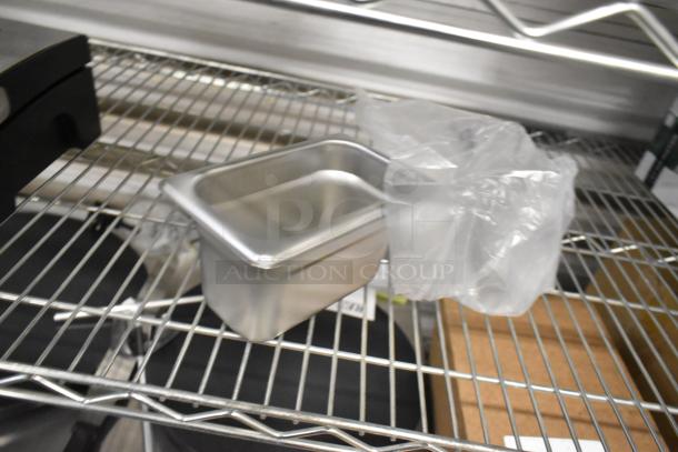 Scratch and dent 1/9 size stainless steel steam table pan on metal shelf, clean and polished, partial packaging visible.