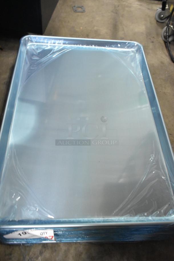 Stack of new Baker's Lane heavy-duty full-size 16-gauge aluminum bun pans, 18" x 26", wrapped in plastic. Quantity tag shows "27".