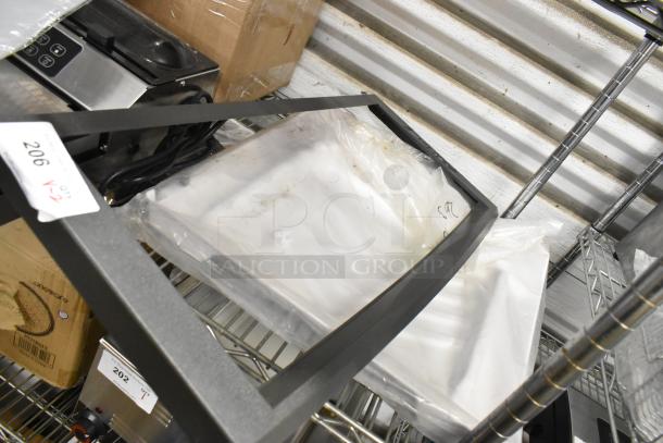 2 new Manitowoc Ice 4010989 water curtain pieces on a metal shelf, auction label visible, in original packaging.