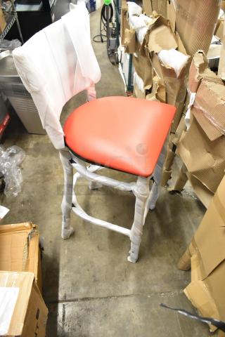 Brand new black bar height chair with red seat cushion, wrapped for protection. Scratch and dent condition. 13 available.