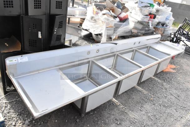Brand new Regency 600S42424224 stainless steel 4 bay sink with dual drain boards, no legs, slight scratches, ideal for commercial use.
