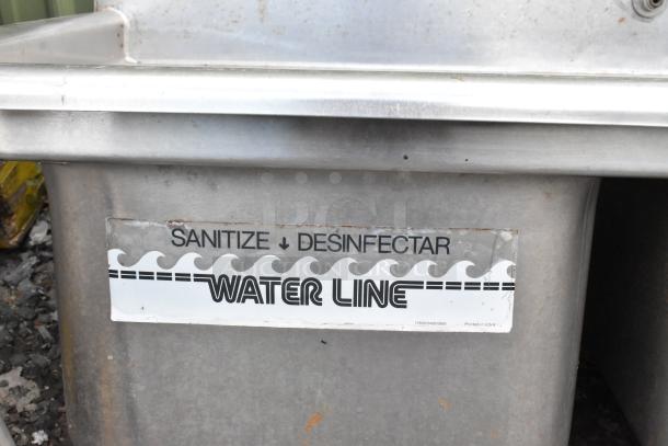 Stainless steel 3 bay sink without legs, visible "Sanitize" label, in used condition.