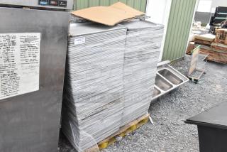 Stack of 590 full-size metal baking pans on a pallet, shrink-wrapped, labeled "219," in used condition.