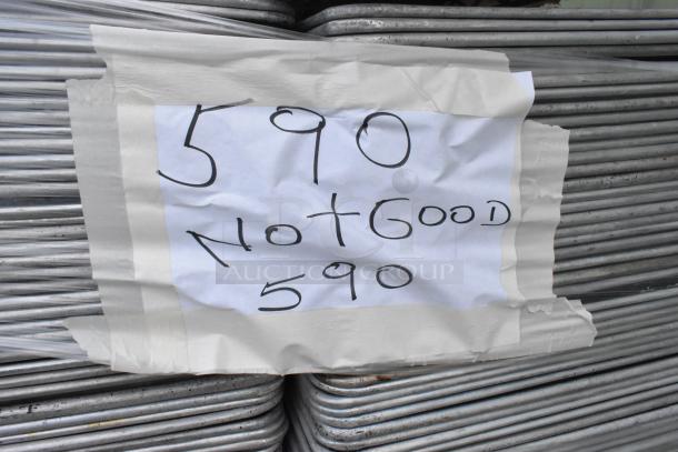 Stack of 590 metal full-size baking pans with visible wear. Sign reads "590 Not Good 590," taped on top.
