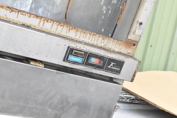 Beverage Air stainless steel commercial 2-door reach-in freezer, rust visible, E Series label, temperature gauge shown.