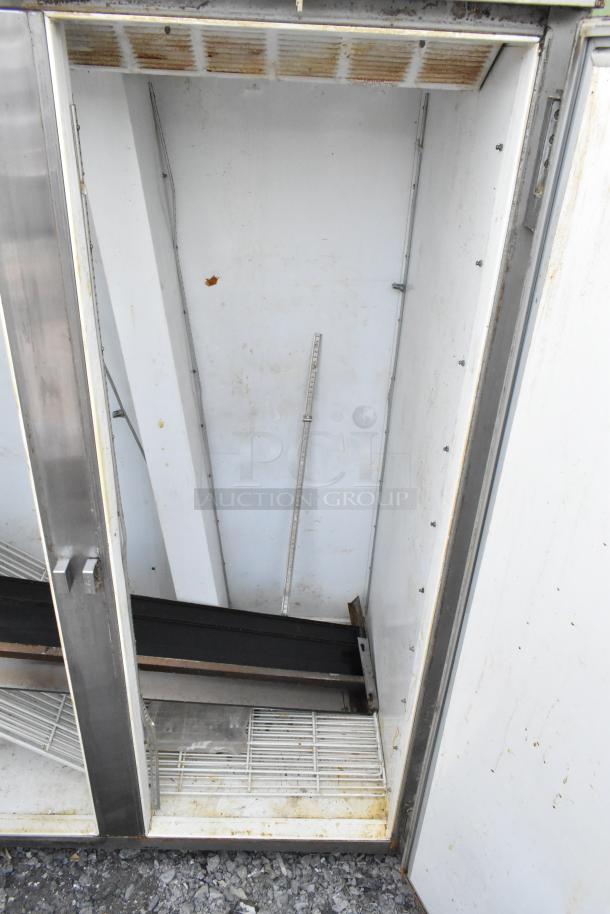Beverage Air stainless steel commercial 2-door reach-in freezer with visible interior shelves. Some signs of wear and rust.