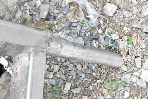 Stainless steel component of Auto-Chlor AC dishwasher, condition shown, placed on gravel surface.