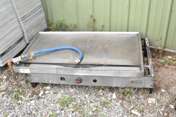 Wolf stainless steel commercial countertop flat top griddle, natural gas powered, with visible connector hose; used condition.