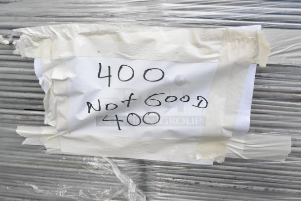 400 metal full-size baking pans, labeled "Not Good" on taped paper, wrapped in plastic. Quantity multiplies auction bid.